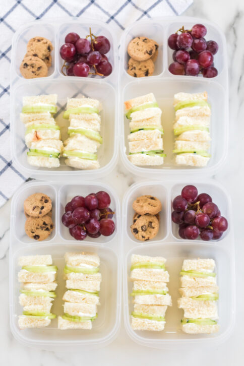 4 lunchboxes packed with Mini Cucumber Sandwiches, cookies and grapes