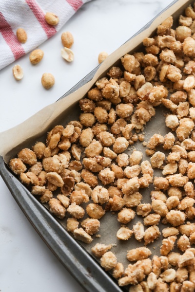 candied coated peanuts spread out on a baking sheet