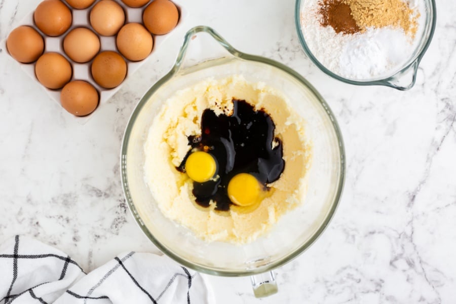 eggs, vanilla and molasses being added into mixing bowl