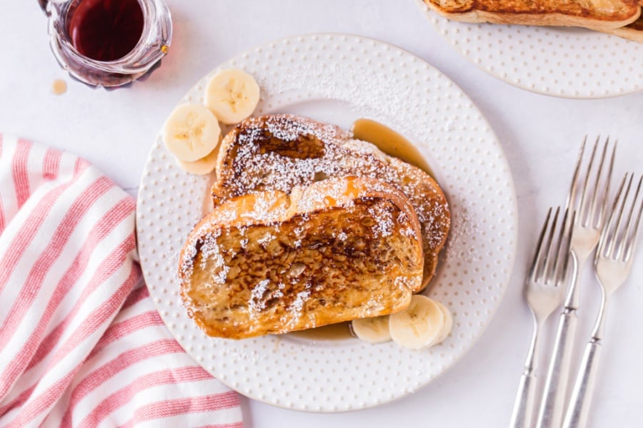 Eggnog French Toast on a plate with sliced bananas