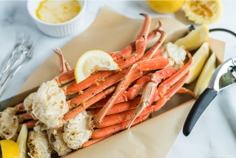 snow crab legs on a serving platter with slices of lemon