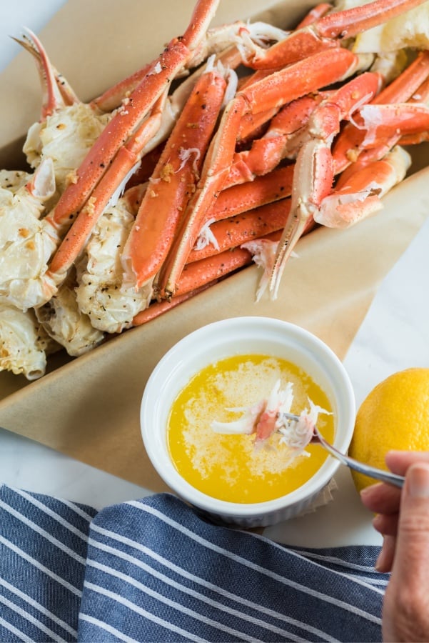 dipping some crab meat into melted butter