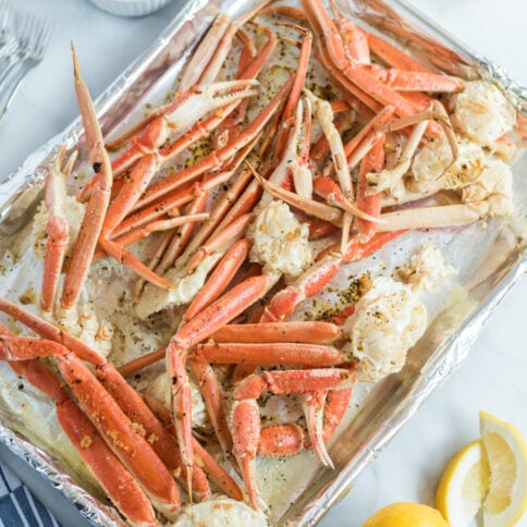 crab leg clusters on a baking sheet