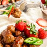 Strawberry Jalapeno Meatballs on a plate with a toothpick picking up one