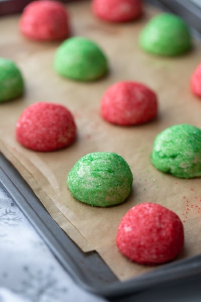 red and green butter cookies on a baking sheet