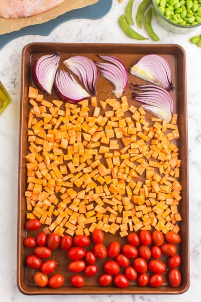 tomatoes, diced potatoes and onions on baking sheet