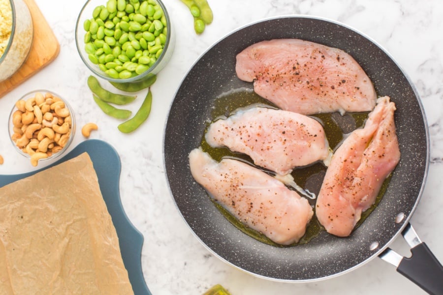 chicken breast cooking in a frying pan