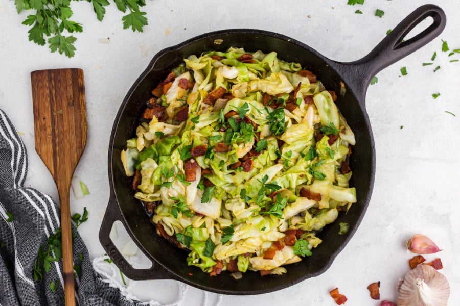 fried cabbage and bacon in a cast iron pan