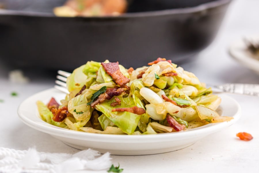 fried cabbage and bacon on a white plate