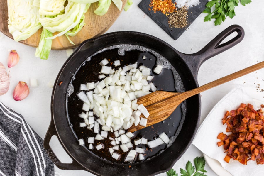 onions in a pan with a wooden spoon