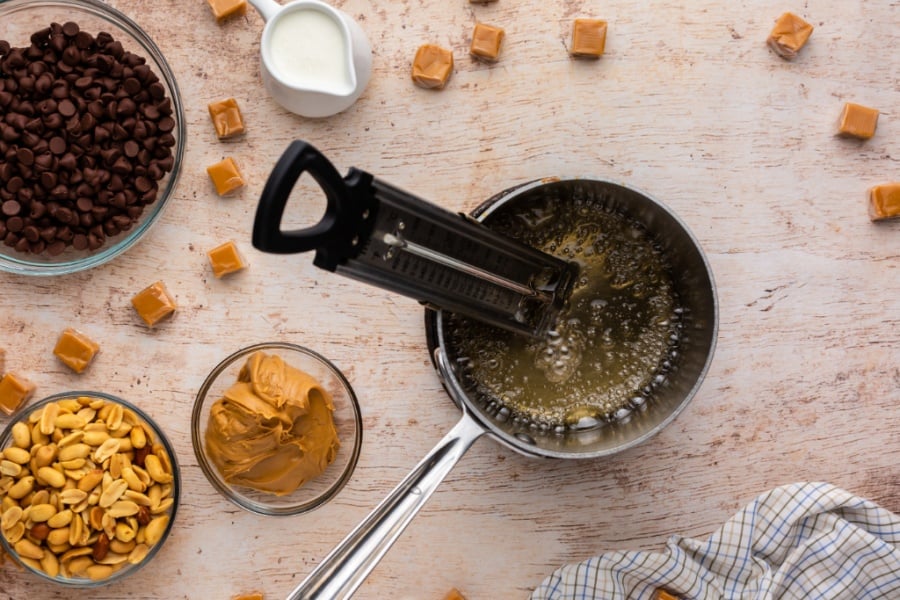 granulated sugar, corn syrup, and water in a sauce pan with a candy thermometer