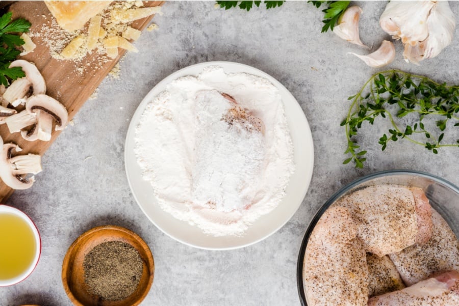 Chicken thigh in plate of flour