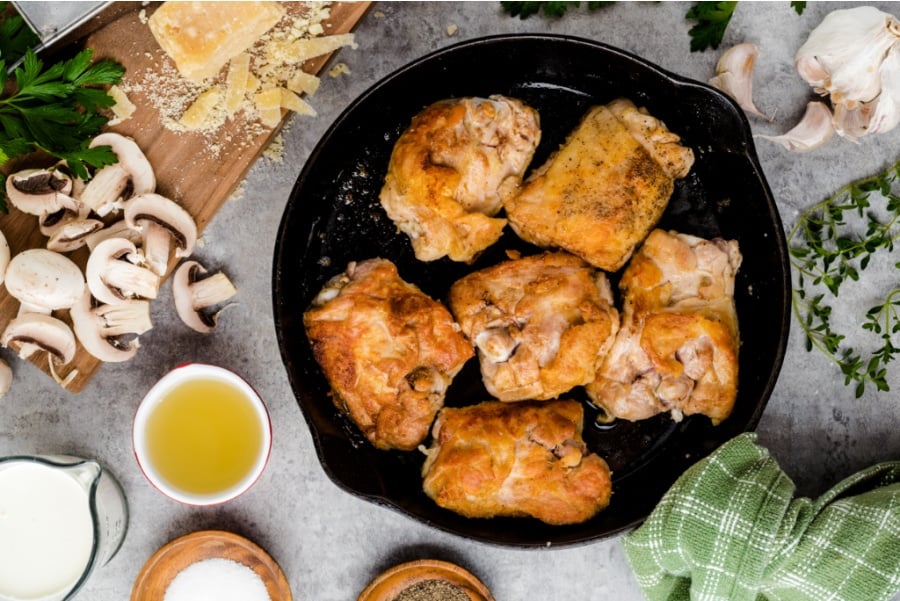 browned chicken thighs in cast iron skillet