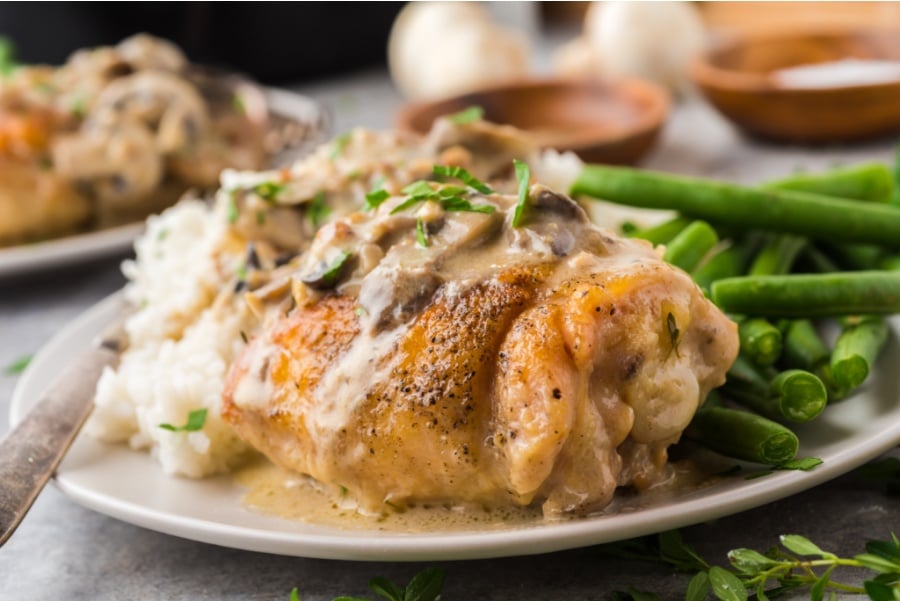 Chicken thighs served with rice and green beans on a plate