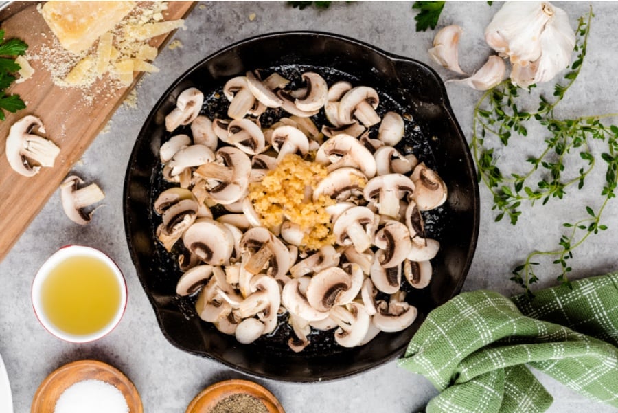 sliced mushrooms and garlic in cast iron pan