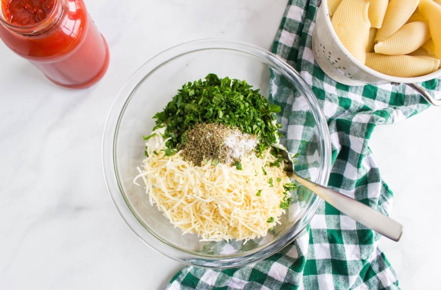 ricotta, shredded cheese, seasoning and spinach in a mixing bowl