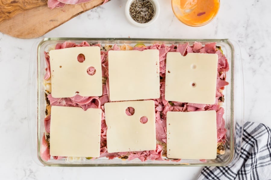 slices of Swiss cheese layered on top of corned beef