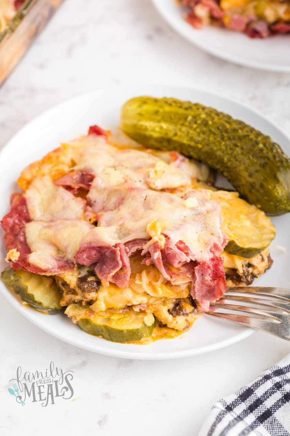 piece of reuben casserole on a plate with a pickle