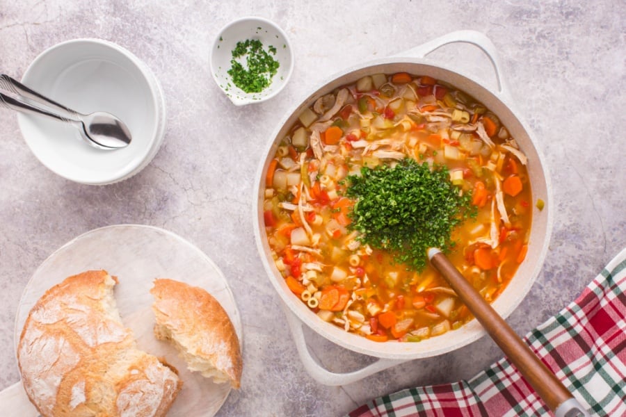 soup in cooking pot, topped with a pile of diced parsely