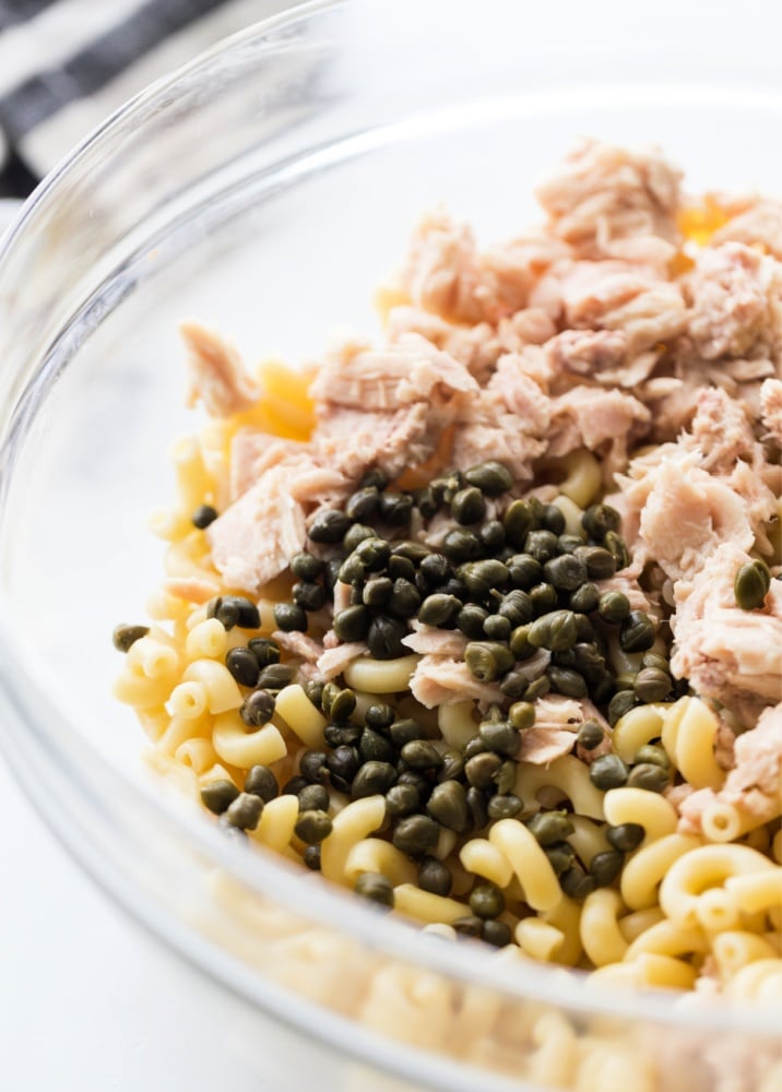 cooked noodles, capers and tuna in a mixing bowl