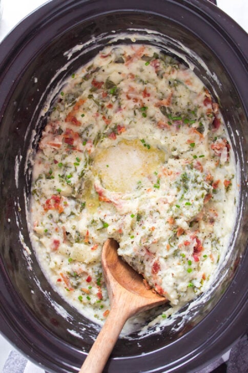 Crockpot Colcannon Potatoes in a slow cooker with a wooden spoon