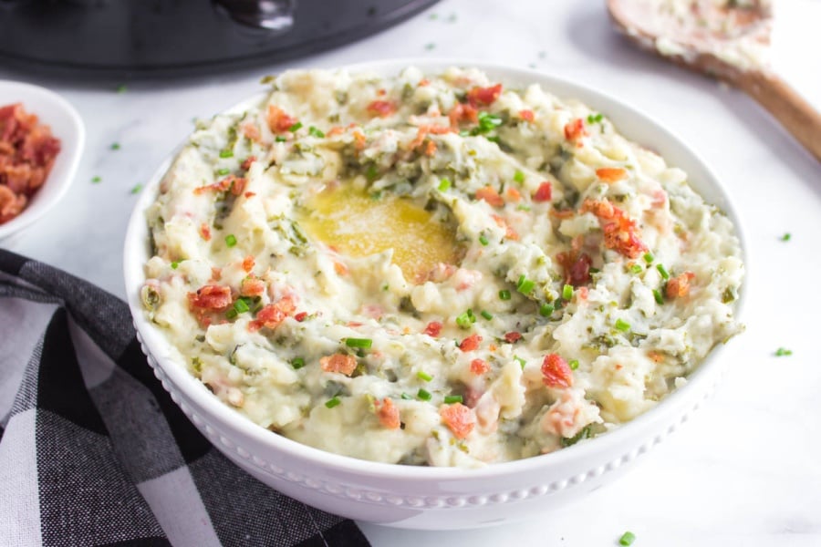 a white serving bowl full of Crockpot Colcannon Potatoes