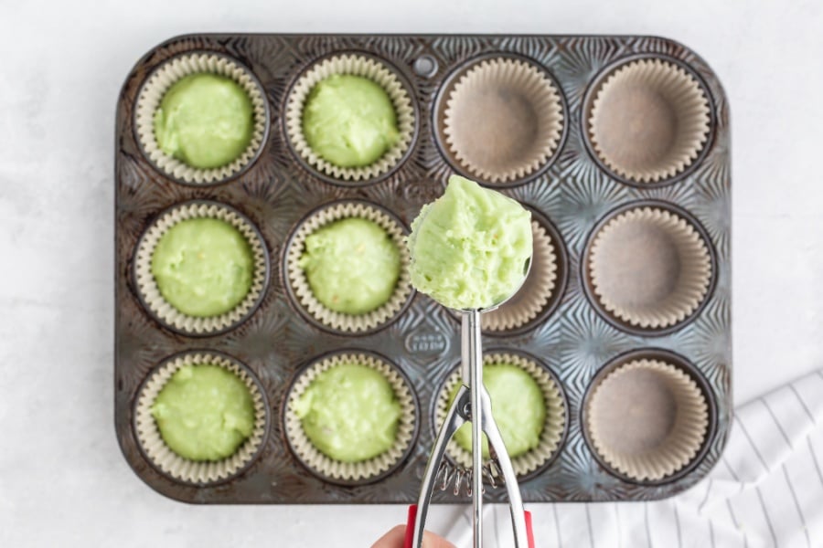 adding muffin batter to muffin tin