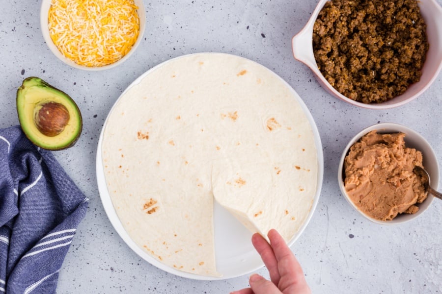 hand lifting up section of tortilla