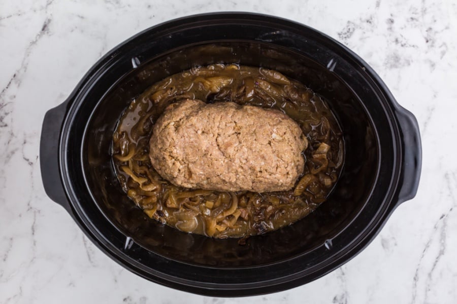 meatloaf placed on top of caramelized onions in crockpot 