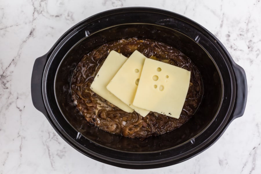 sliced cheese on top of meatloaf in slow cooker