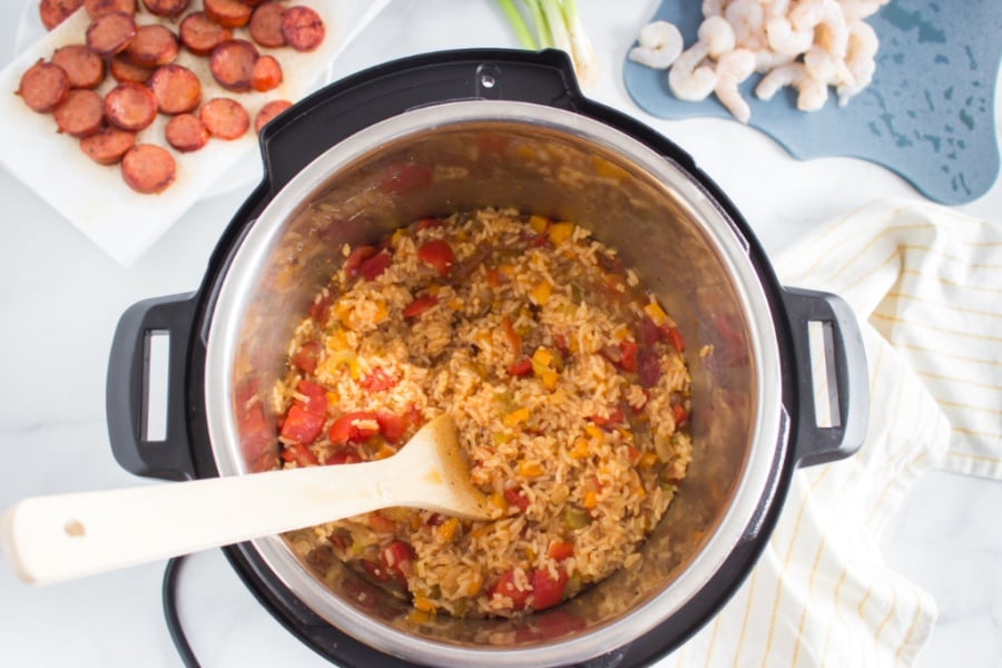 wooden spoon stirring Jambalaya in instant pot