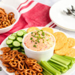 Pimento Cheese Spread recipe in a bowl with pretzels, cracker, celery and cucumbers