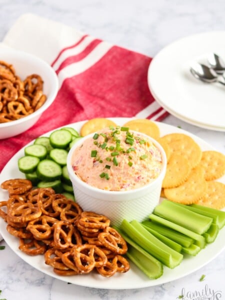 Pimento Cheese Spread recipe in a bowl with pretzels, cracker, celery and cucumbers