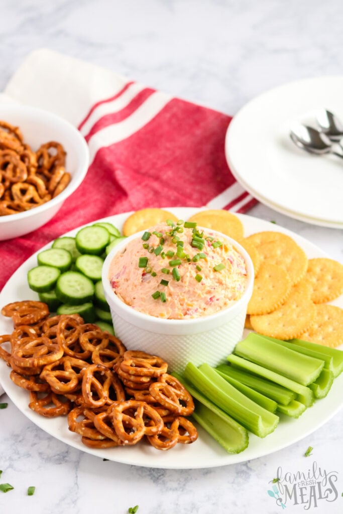 Pimento Cheese Spread recipe in a bowl with pretzels, cracker, celery and cucumbers