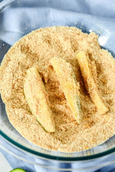 coating zucchini spears in breading