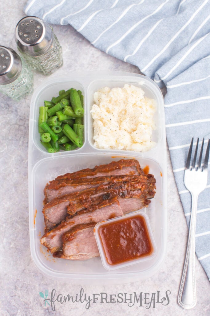 leftover bbq brisket in a lunchbox with green beans and mashed potatoes