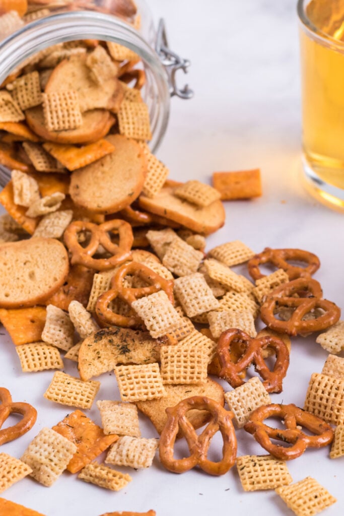 Dill Pickle Chex Mix pouring out of glass jar