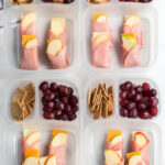 4 lunchboxes with ham apple cheese wraps in them