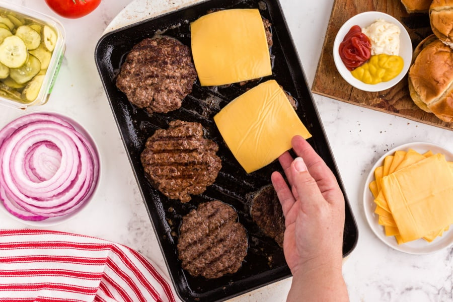 Placing cheese slices on burgers