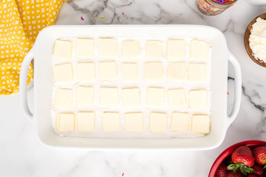 tabs of butter placed on top of cake mix