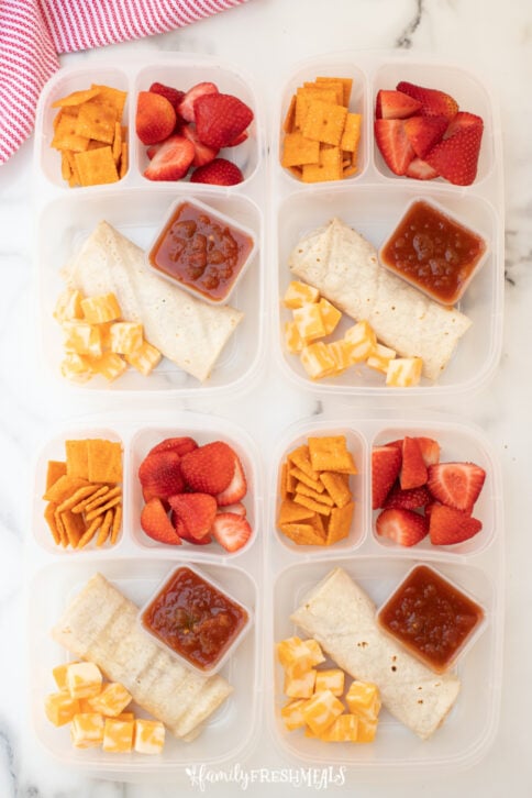 4 lunchboxes packed with burritos, strawberries, crackers, cheese and salsa-5