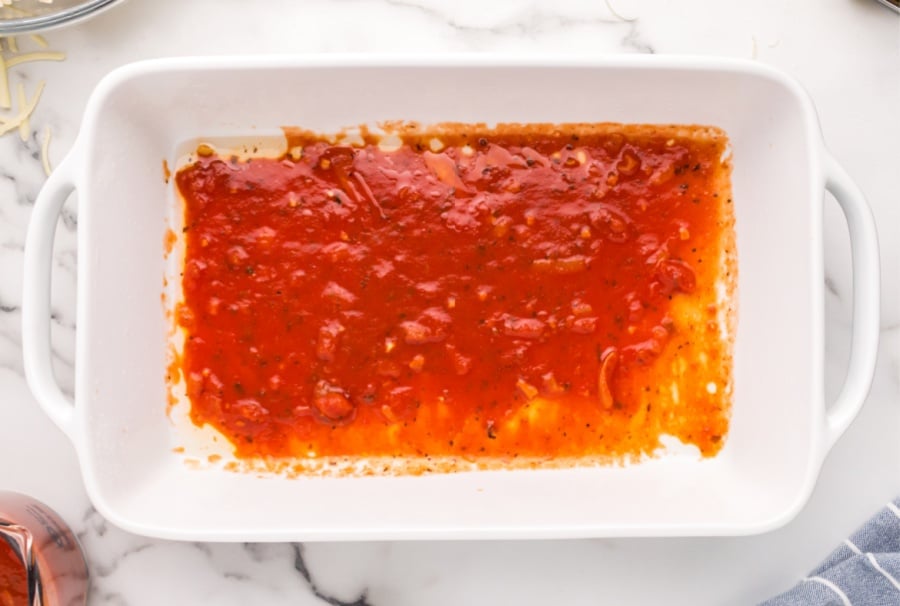 marinara sauce spread into baking dish