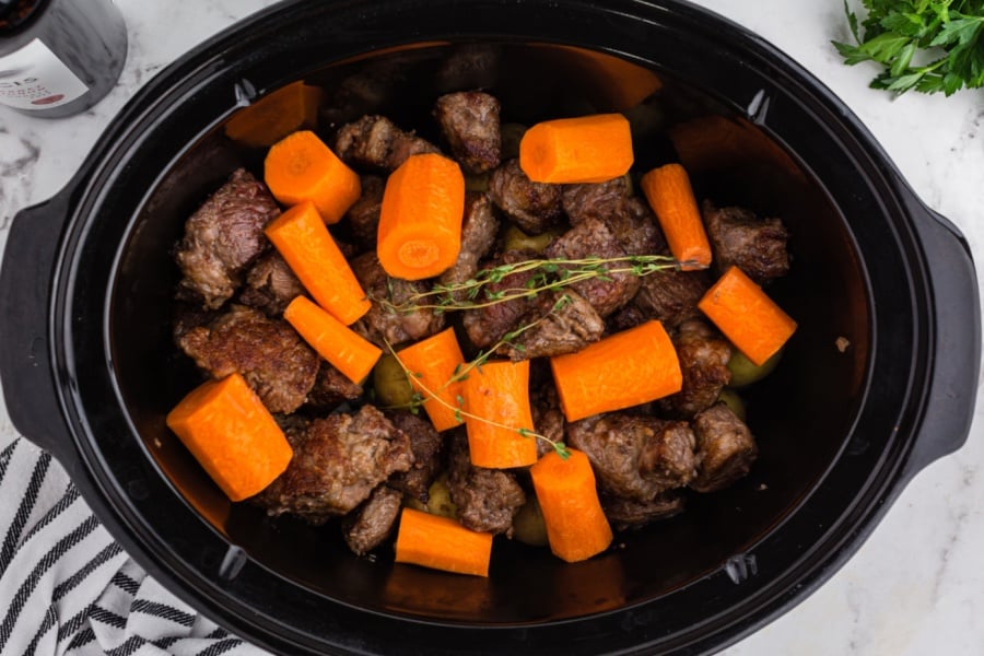 meat and veggies placed in slow cooker