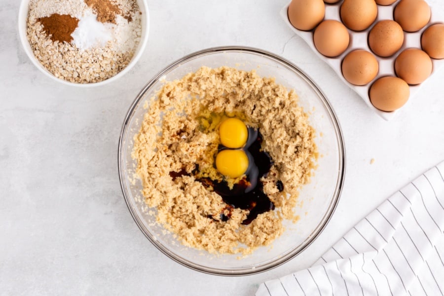 adding eggs and molasses into mixing bowl 