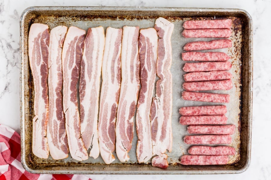 bacon and sausages on baking sheet