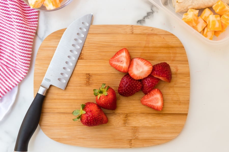 Strawberries cut up on a cutting board