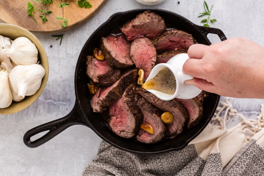 pouring butter over sliced tenderloin