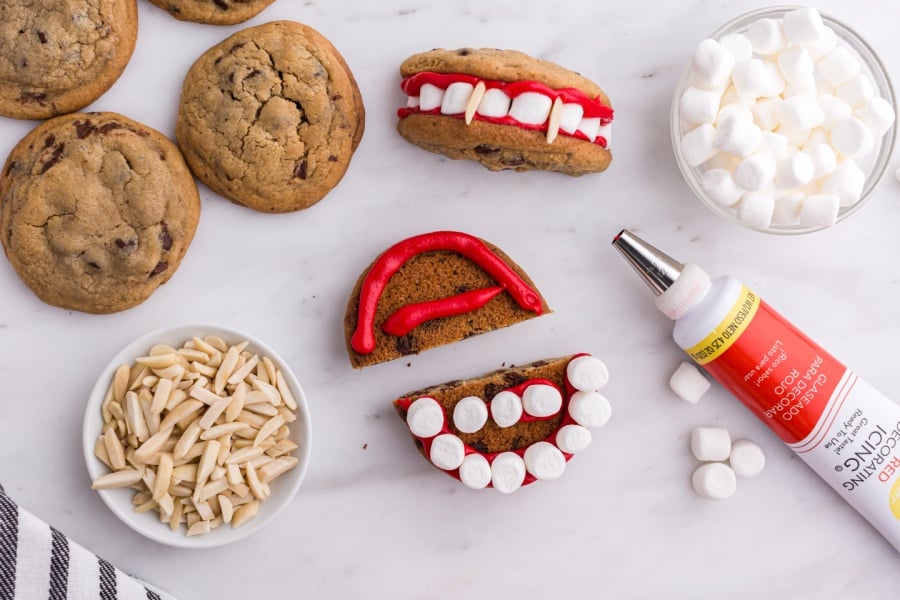 showing how to put marshmallow teeth and icing on cookie 