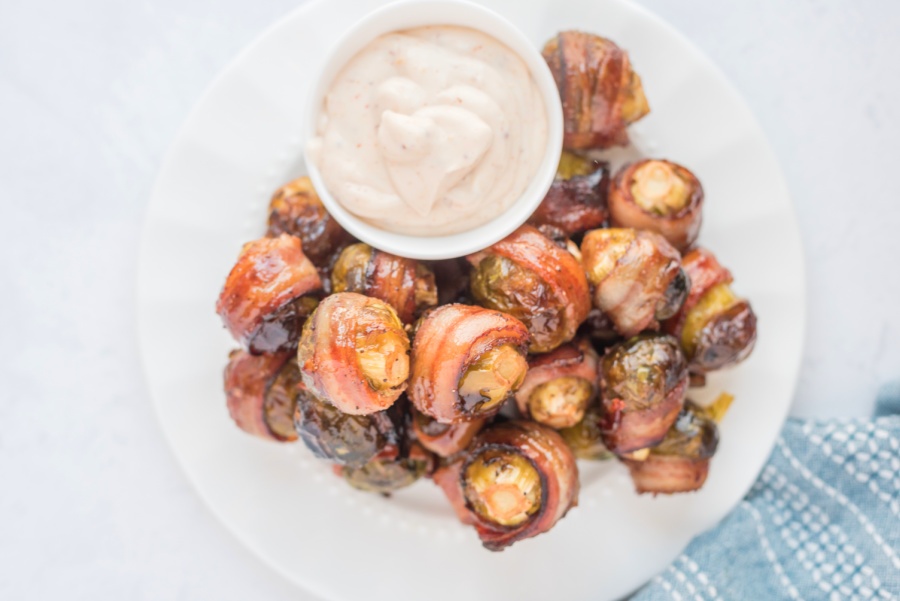 Bacon Wrapped Brussels Sprouts on a plate with dipping sauce