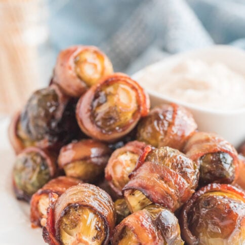 Bacon Wrapped Brussels Sprouts on a plate with sauce